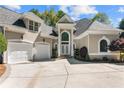 Elegant stucco home boasts a well-manicured front yard, a two-car garage, and a stylish entryway with intricate stonework at 1002 Wetherby Way, Johns Creek, GA 30022