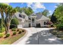 Stunning stucco home featuring mature trees, pristine landscaping, and a curved driveway for added curb appeal at 1002 Wetherby Way, Johns Creek, GA 30022