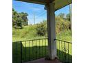 Covered porch featuring a wrought iron railing and a view of overgrown shrubs at 1902 Godby Rd, Atlanta, GA 30349