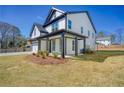 Side view of this two-story home with a covered front porch, showcasing the landscaping and architectural details at 1064 Eastview Ne Rd, Conyers, GA 30012