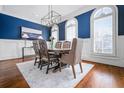 Formal dining room with wood floors, blue accent wall, and natural light from arched windows at 3641 Broughton Se Cir, Atlanta, GA 30339