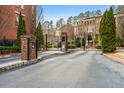 View of the brick entrance of a community, with black iron gates and landscaped grounds at 3641 Broughton Se Cir, Atlanta, GA 30339