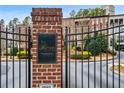 Community entrance featuring a brick sign, gate, and professional landscaping at 3641 Broughton Se Cir, Atlanta, GA 30339