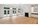 Open living room with a fireplace, wet bar, and French doors leading to a deck at 725 Riley Pl, Sandy Springs, GA 30327