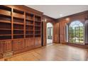 Office with wood walls, hardwood floors, built-in bookshelf, arched window and doorway at 725 Riley Pl, Sandy Springs, GA 30327