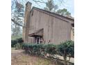 Angle view of the exterior with mature landscaping and a chimney at 43 Willowick Ct, Stonecrest, GA 30038