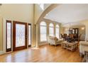 Light-filled foyer with hardwood floors, decorative glass front door, arched windows, and adjacent living and dining rooms at 589 Cook Dr, Ellenwood, GA 30294