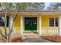 Charming green double front door with sidelights and white columns on a yellow house, offering a warm welcome at 2142 Graystone Pkwy, Grayson, GA 30017