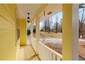 Inviting covered front porch with white railing on a charming yellow house, perfect for enjoying the outdoors at 2142 Graystone Pkwy, Grayson, GA 30017