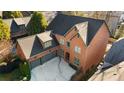 An aerial perspective shows the brick home, two car garage, driveway, and surrounding mature landscaping at 29 Cliftwood Dr, Sandy Springs, GA 30328