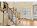 Bright foyer features hardwood floors, staircase with iron spindles, and a front door with sidelights at 1085 Highland Crest Ct, Mableton, GA 30126