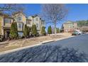 Street-level view of townhomes with manicured lawns and mature trees on a sunny day at 3966 Covey Flush Sw Ct # 20, Smyrna, GA 30082