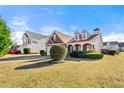 View showcasing the home's architecture, with a manicured lawn and mature landscaping at 3296 Quincey Xing, Conyers, GA 30013