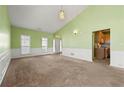 Bright living room featuring neutral carpet, and a view into the entry and kitchen at 3296 Quincey Xing, Conyers, GA 30013