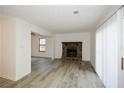 Open-concept living room featuring a cozy stone fireplace, wood-look flooring, and a light-filled space with access to the patio at 1314 N Lea Se Ct, Smyrna, GA 30080