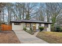 Ranch home with a concrete driveway, and a well-manicured front yard with mature trees at 1090 Indale Sw Pl, Atlanta, GA 30310