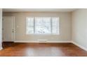 Bright living room featuring wood floors, neutral walls, a large window and a white front door at 1850 Brewer Sw Blvd, Atlanta, GA 30310