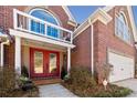 Inviting front entrance with double red doors, brick facade, and a well-maintained walkway to the 2-car garage at 1034 Fairview Club Cir, Dacula, GA 30019