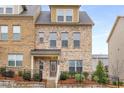 Attractive brick-front townhome featuring a cozy porch and manicured landscaping at 3320 Reagan Way # 80, Lawrenceville, GA 30044