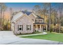 Beautiful home with brick and stone exterior, complemented by a well-manicured lawn and a spacious driveway at 5887 Thistle Ct, Douglasville, GA 30135