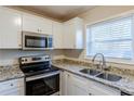 Modern kitchen showcasing stainless steel oven, microwave, granite countertops, and white cabinets at 2080 Dellwood Pl, Decatur, GA 30032