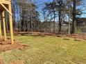 Green backyard with fresh sod and trees surrounding a lake at 2021 Shallowford Rd, Marietta, GA 30066