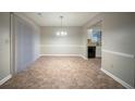 Open dining area adjacent to the kitchen with neutral walls, tile flooring, and modern lighting fixtures at 5087 Donnell Way, Decatur, GA 30035