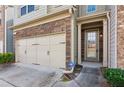 Exterior view of a two-story townhome with stone accents around the garage at 2293 Chancery Mill Ln, Buford, GA 30519