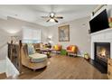 Bright living room featuring a fireplace, hardwood floors, and a ceiling fan at 236 Balaban Cir, Woodstock, GA 30188