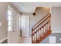 Bright entryway with tiled flooring, staircase with wood railing, and a coat closet near the front door at 4808 Sunview Ct, Suwanee, GA 30024