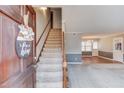 Inviting entryway featuring a carpeted staircase and views into the living room with hardwood flooring at 4808 Sunview Ct, Suwanee, GA 30024