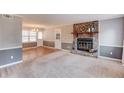 Spacious living room with plush carpet, fireplace with stone surround, and natural light from large windows at 4808 Sunview Ct, Suwanee, GA 30024