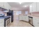 Well-lit kitchen featuring stainless steel appliances and white cabinetry at 1070 Thornwood Cir, Covington, GA 30016