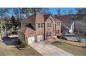 Brick two-story home with two-car garage, complimented by a green lawn and mature trees at 10950 Glenhurst Pass, Duluth, GA 30097