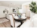 Cozy dining area with a round table, white upholstered chairs, and natural light, creating a comfortable eating space at 2456 Honey Way, Conyers, GA 30013