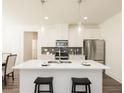 Bright kitchen with stainless steel appliances, white cabinets, island with seating, and modern pendant lighting at 2456 Honey Way, Conyers, GA 30013