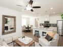 Open concept living room with eat-in kitchen, a large mirror above the fireplace, and ceiling fan at 2456 Honey Way, Conyers, GA 30013