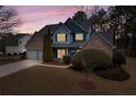 Inviting two-story home with manicured lawn, mature trees, and a twilight sky at 923 Buckhorn Bnd, Locust Grove, GA 30248