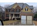 Attractive two-story brick house featuring a covered front porch and a two-car garage at 1831 Nours Landing Way, Duluth, GA 30097