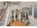 Inviting foyer with hardwood floors, staircase, and decorative guitar leading to arched entryways at 8034 Bradshaw Ct, Douglasville, GA 30134