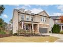 Inviting two-story home featuring a covered porch, stone accents, and well-kept landscaping in a desirable neighborhood at 322 Kells Ct, Woodstock, GA 30188