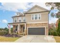 Charming two-story home with a stone facade, covered front porch, and a well-manicured lawn with professional landscaping at 322 Kells Ct, Woodstock, GA 30188