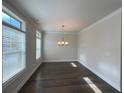 Bright dining room with large windows, dark hardwood floors, and an elegant chandelier at 3879 Glenview Club Ln, Duluth, GA 30097