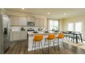 Open kitchen and dining area features gray cabinets, stainless appliances and wood floors at 2464 Bayberry St, Acworth, GA 30101
