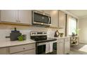 Close up of stainless steel oven with range hood, subway tile backsplash, and gray cabinets at 2464 Bayberry St, Acworth, GA 30101