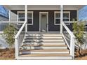 Close up of the gray home's front porch featuring a light-gray front door and white wood stairs at 260 Miller Reed Se Ave, Atlanta, GA 30315