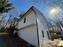 Angle view of the exterior with white siding, black trim, concrete foundation and side staircase at 2836 Brook Dr, Douglasville, GA 30135