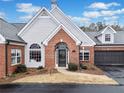Inviting home exterior with brick facade, gray siding, manicured bushes, and a two-car garage at 140 Stonegate Ln, Canton, GA 30114
