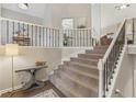 Elegant staircase with a carpet runner and decorative iron railing, connecting multiple levels at 3520 Bethwicke Dr, Cumming, GA 30040