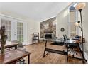 Bright living room featuring a stone fireplace, wood floors, with natural light from large windows at 670 Westbrook Pl, Lawrenceville, GA 30044